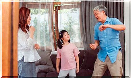 A family dancing in the living room. 