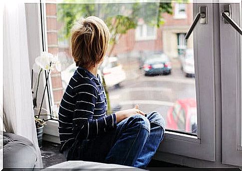 A child with autism disorder looking out the window.