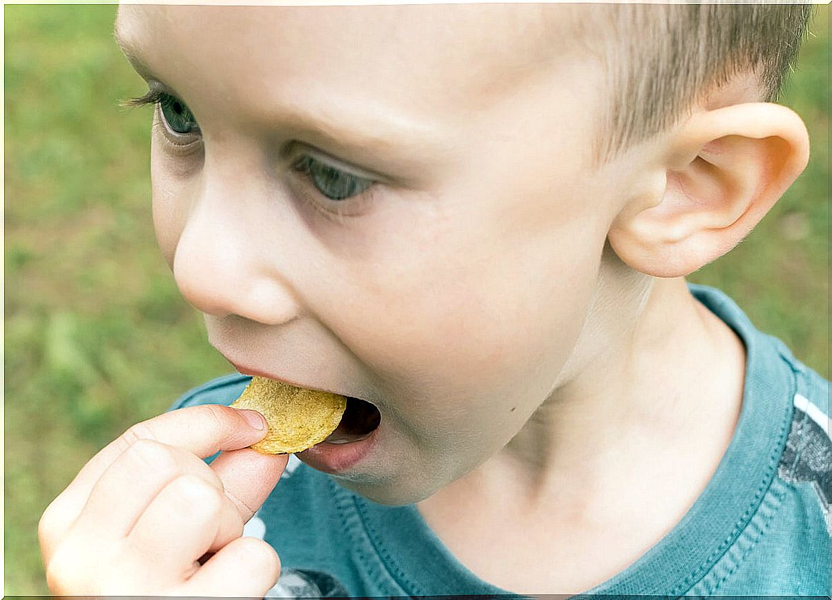 Child eating crisps with too much salt.