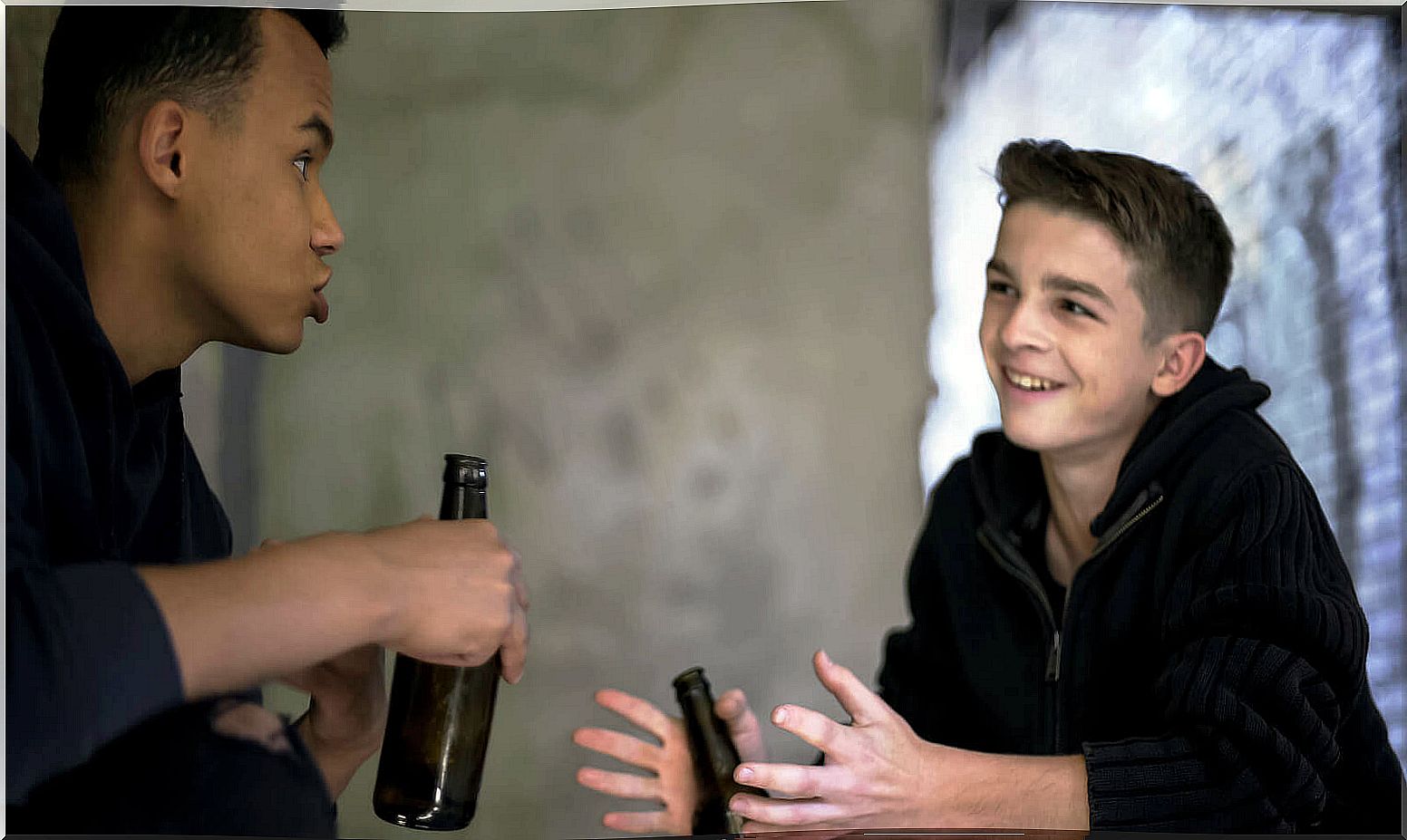 Two teenagers drinking alcohol.