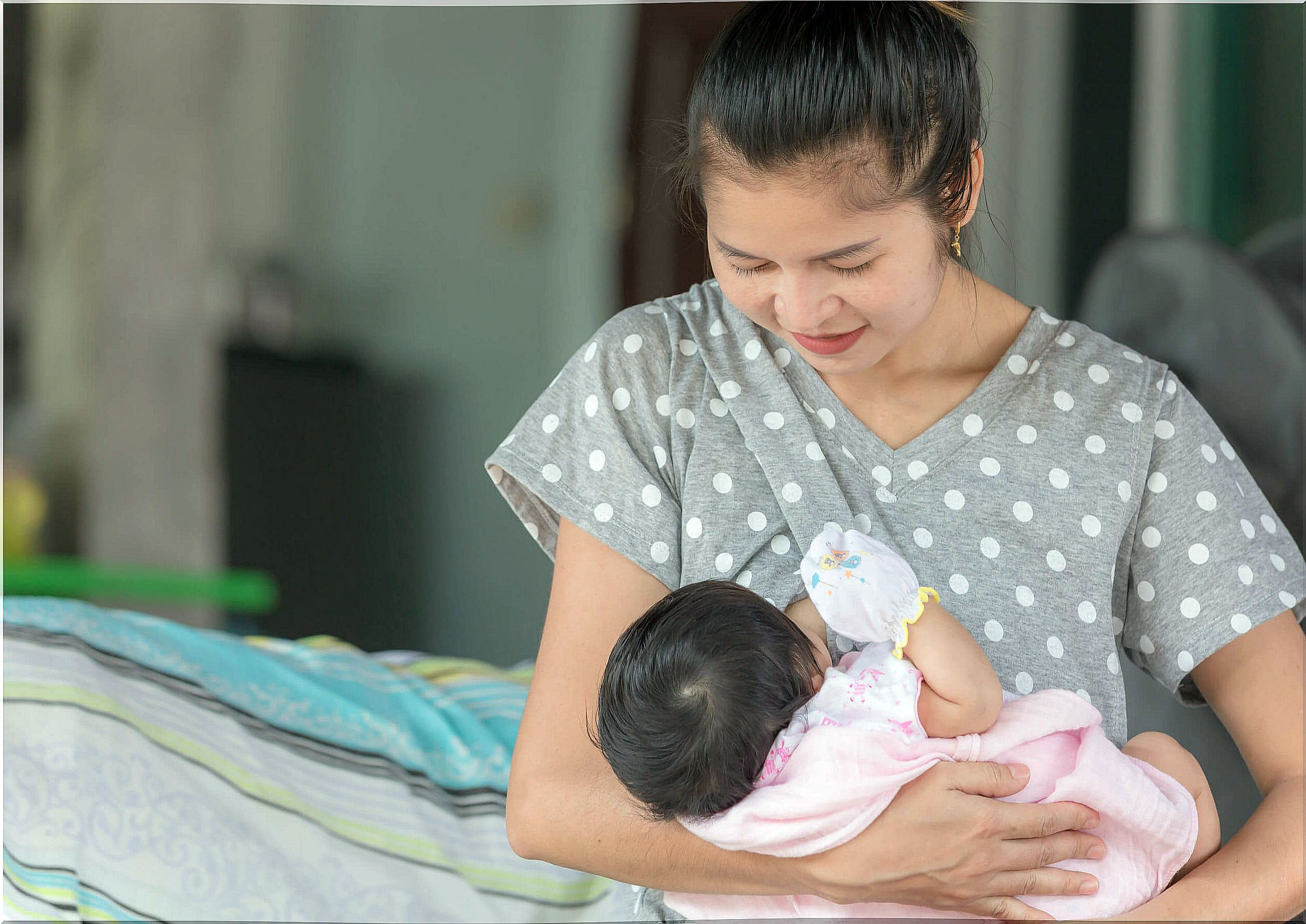 Mom breastfeeds her baby with nipple protectors.