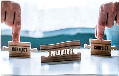 wooden figurines representing the mediation of a conflict