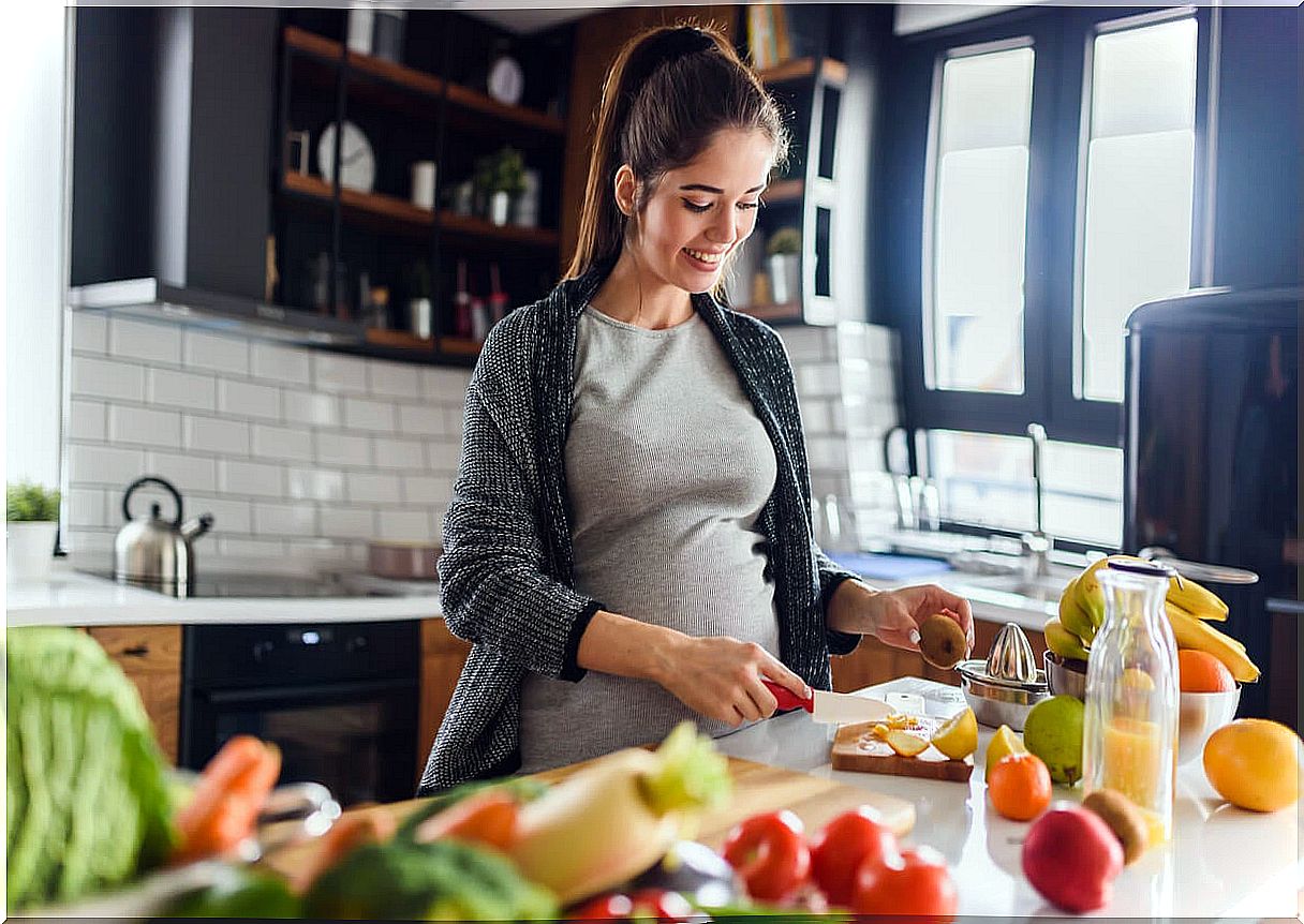 A pregnant woman cooking. 