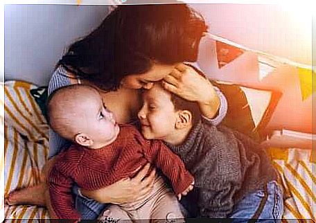 A mother who hugs her two children. 