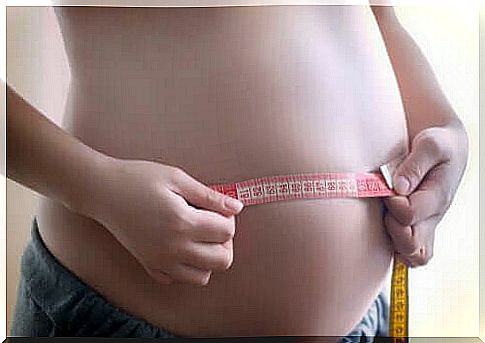 woman measuring her belly during pregnancy