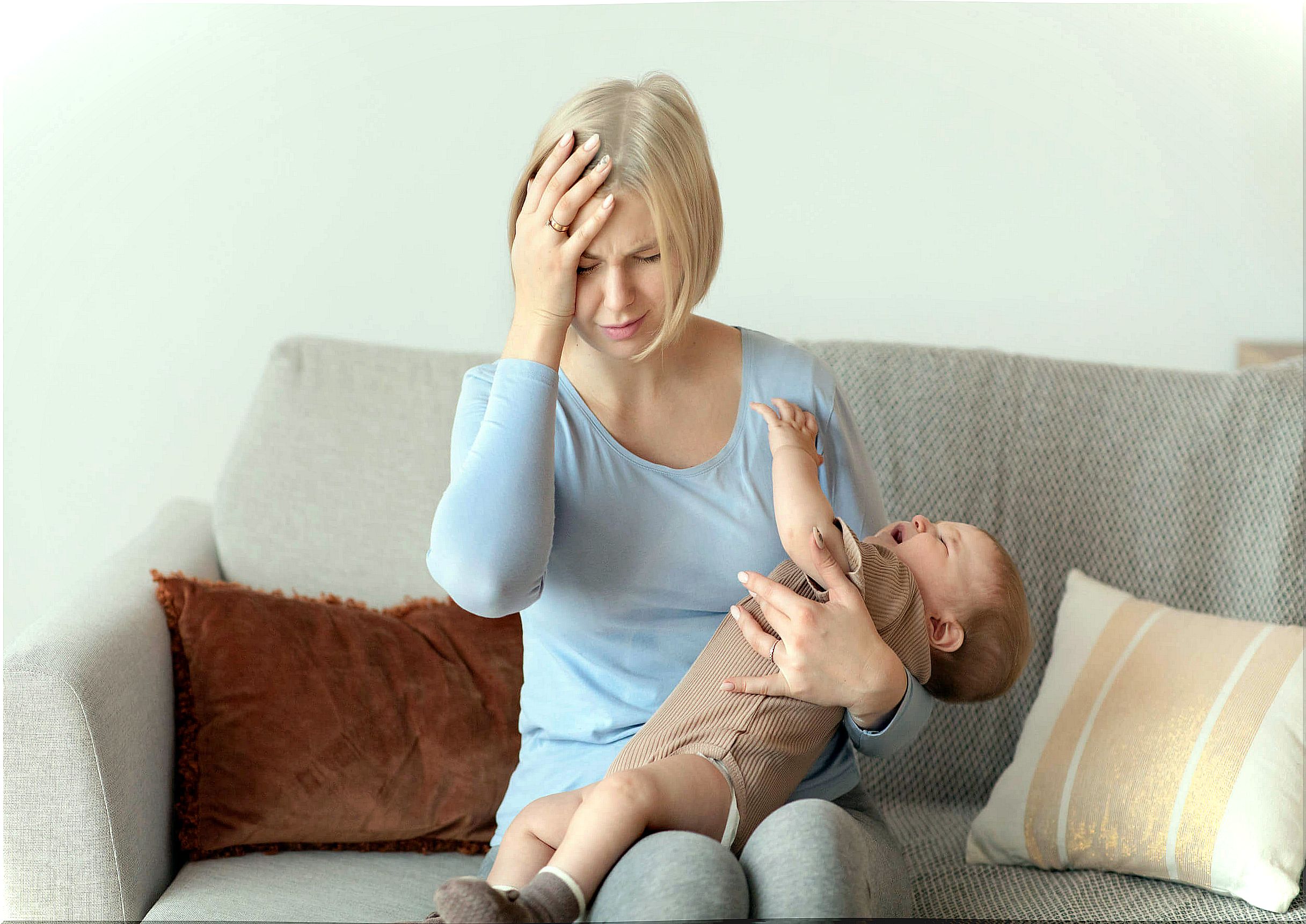 Tired mother with her crying baby in her arms. 