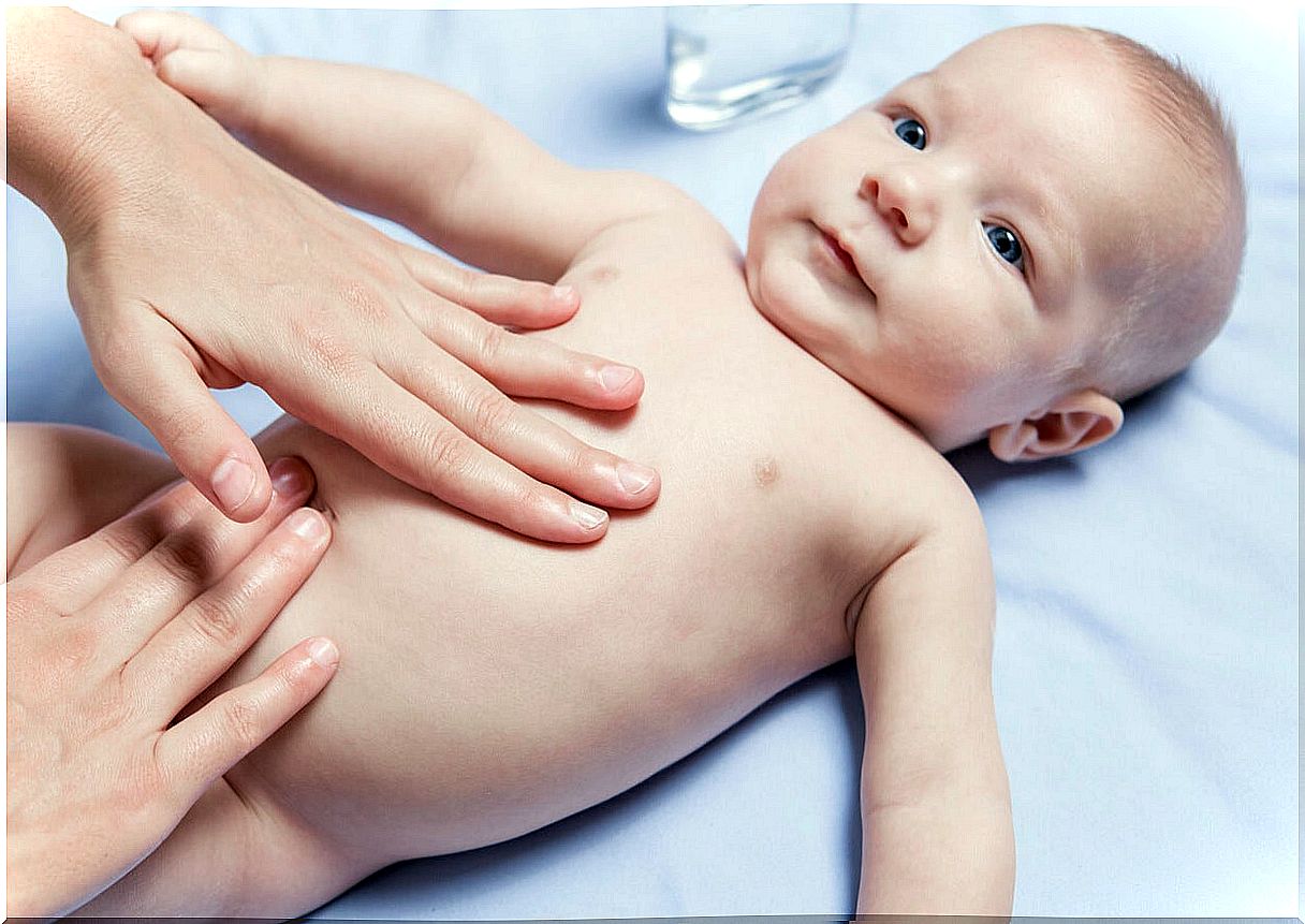 Mother doing abdominal massage to her baby.