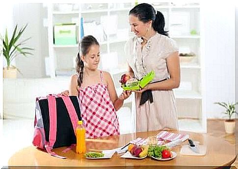 mother giving her lunch to her daughter