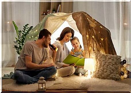 Parents and their little daughter reading.