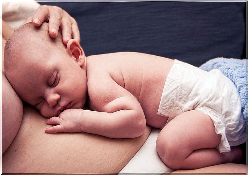 Newborn baby asleep on his mom's tummy