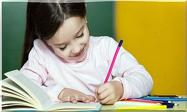 Happy little girl working, with pencil and book 