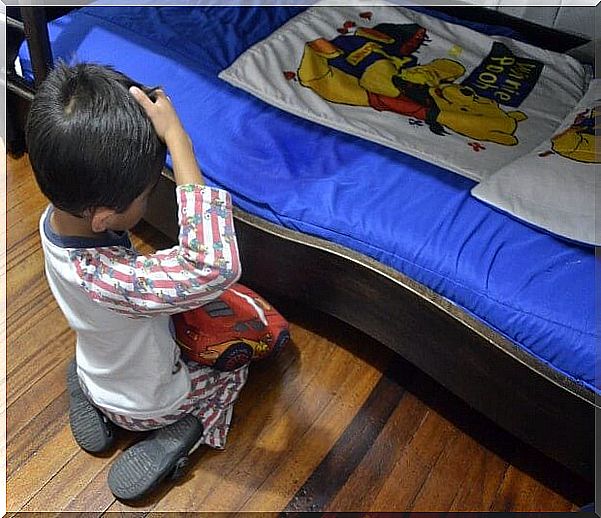 Child facing his wet bed after wetting the bed 